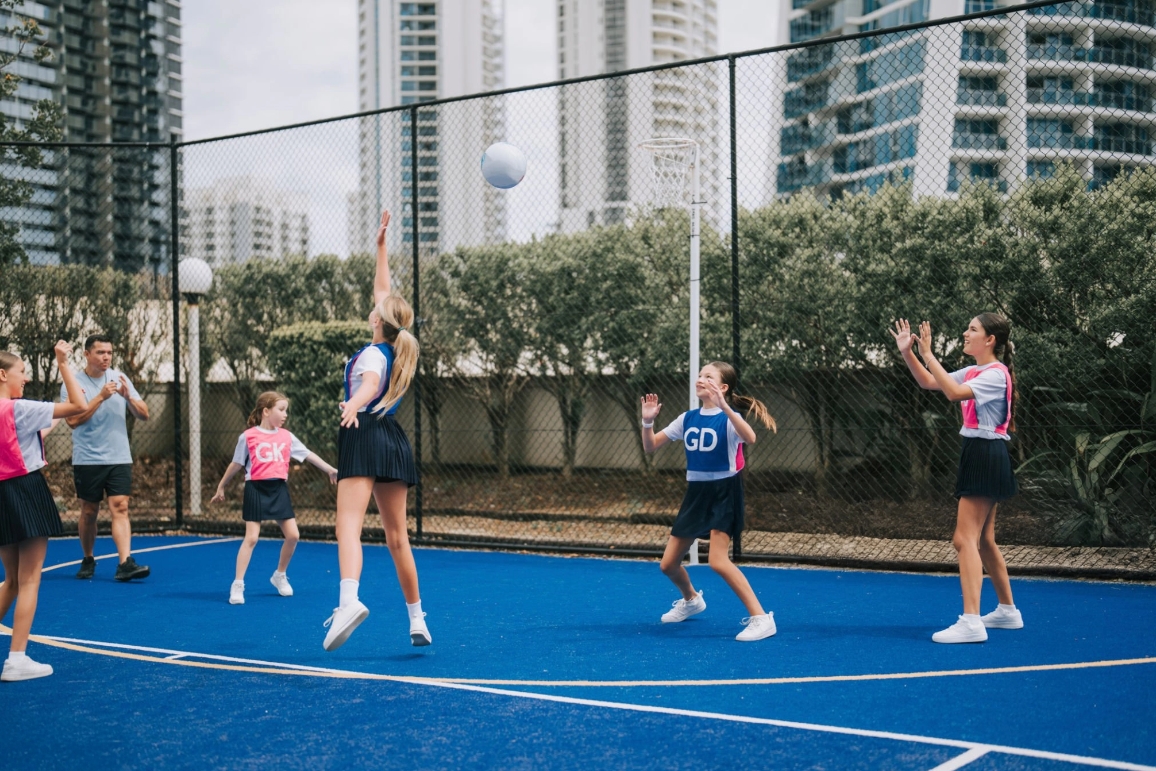 A group of cheerleaders at the beach, promoting school sports with colorful equipment, embodying energy and teamwork.